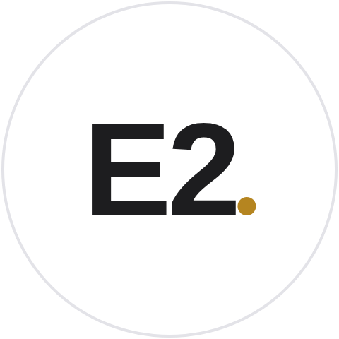 The E2 badge in ink on a white circle, with a gold period